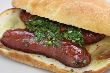 En la descripción del choripán, TasteAtlas lo presenta como “lo último en comida callejera argentina” y lo define como un sándwich que combina una salchicha de chorizo con distintos condimentos dentro de un pan crocante