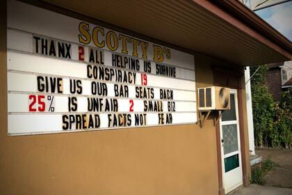 En la entrada de un bar, "Gracias a todos quienes nos ayudan a sobrevivir Conspiración-19"