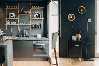 En la estantería (Casa Superí), vasos de vidrio soplado, piezas de barro y platos de Murano italianos de los años '70 (Damax). Luces (11.11 Home & Deco). Mesa de madera quemada (El taller).