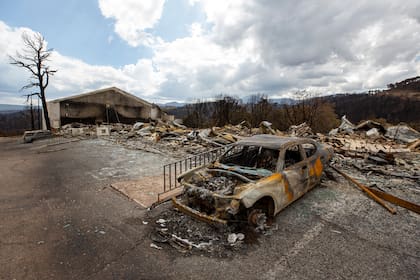 En la foto, un coche carbonizado y los restos del hotel Swiss Chalet tras ser destruido por el incendio de South Fork en el pueblo de montaña de Ruidoso, Nuevo México, el sábado 22 de junio de 2024. (AP Foto/Andres Leighton)