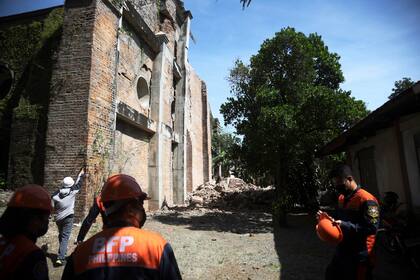 En la imagen, bomberos parados junto a una iglesia dañada por un fuerte sismo en Ilocos Norte, en el norte de Filipinas, el 26 de octubre de 2022. (AP Foto)