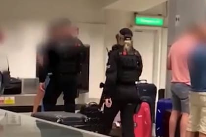 En la imagen, la policía de Manchester al intervenir cuando los pasajeros tomaban sus valijas tras saltar a la cinta de equipaje.