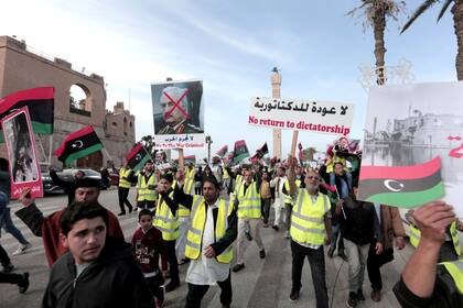 En la imagen, manifestantes, con chalecos amarillos, protestan mientras ondean banderas libias y corean consignas contra el mariscal de campo libio Khalifa Hifter, en Trípoli, Libia, el 19 de abril de 2019. (AP Foto/Hazem Ahmed, archivo)