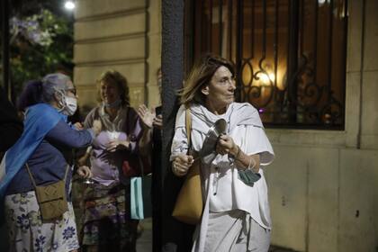 En la izquierda de imagen, con camisa de jean y una bandera argentina sobre su espalda, Ximena de Tezanos Pinto se sumó al reclamo de Justicia en la puerta de su casa.