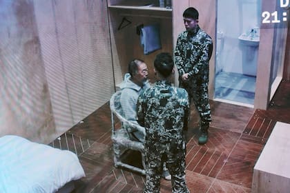 En la performance se ve al artista chino custodiado de forma permanente