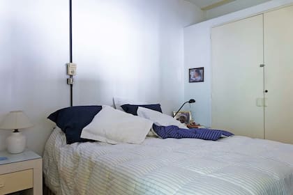 En la planta alta está la suite principal. El ambiente se resolvió con pocos elementos: ropa de cama en blanco, mesas de luz a tono, y almohadones en negro para contrastar.