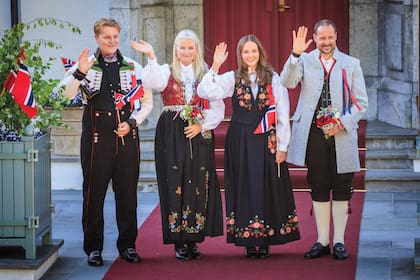 En la puerta de Skaugum, su residencia oficial, y vestidos con trajes típicos, Sverre Magnus, Mette-Marit, Ingrid y Haakon saludan a la gente que se dio cita para verlos.