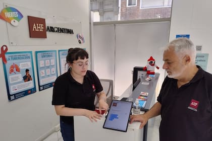 En la recepción AHF, con el número de DNI o pasaporte se pide el turno para la consulta médica o un testeo, explican Miguel Pedrola, director científico para América Latina y el Caribe, y Clara, encargada de hacer las pruebas