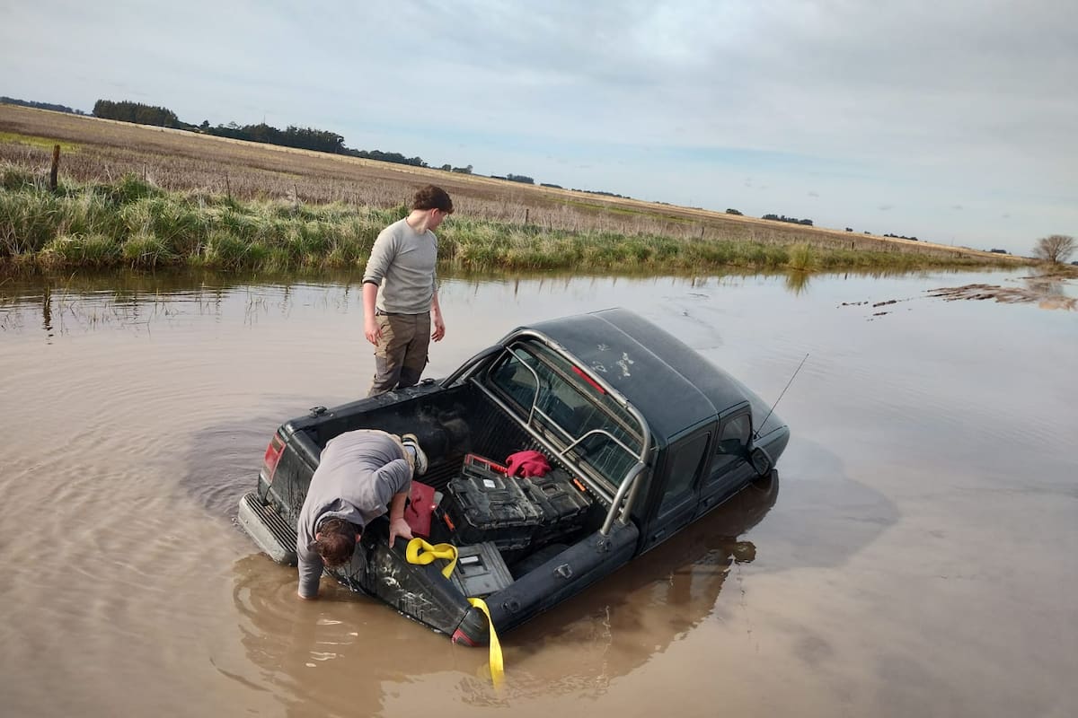 En la ruta 228, kilómetro 25, en Necochea, contratistas rurales intentan sacar una camioneta encajada
