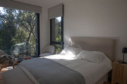 En la suite principal, sillones (Bull Buenos Aires) y un taco de madera como mesa de luz.