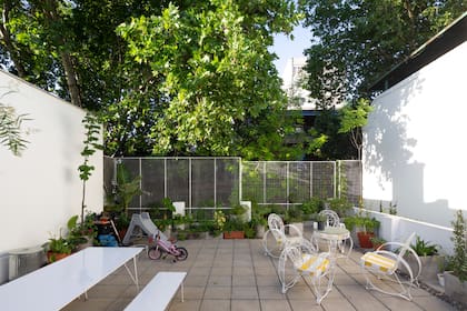En la terraza que da a la calle, mesa y banco (Oficios Asociados) y juego de jardín vintage recuperado.