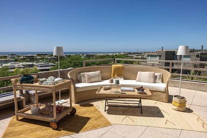 En la terraza –otro de los espacios privilegiados de la casa desde donde se domina la Brava de José Ignacio–, un living con muebles de ratán con alfombras de polipropileno, una novedad de Sentido que la familia incorporó para hacer picnics o ir a la playa.
