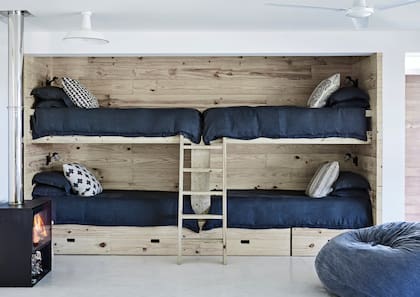 En las paredes laterales del garage, se hicieron nichos revestidos en pino reforestado para empotrar cuchetas bien diseñadas. La idea era tener lugar de sobra para que los chicos recibieran amigos.