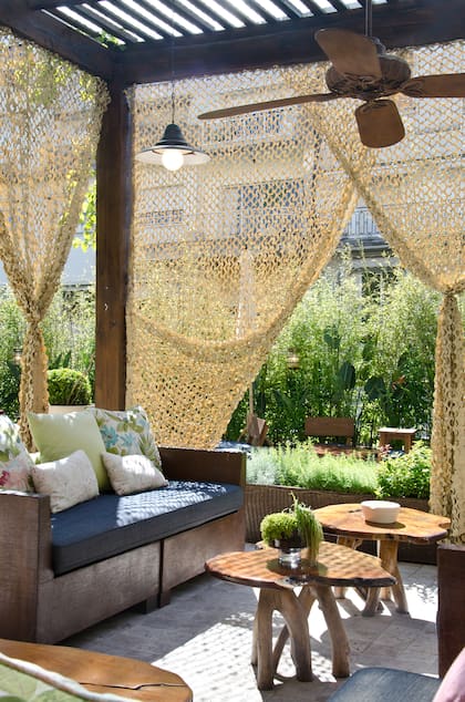 En lugares urbanos, como patios y terrazas, los toldos calados apaciguan el sol, delimitan sutilmente la zona y la hacen más íntima