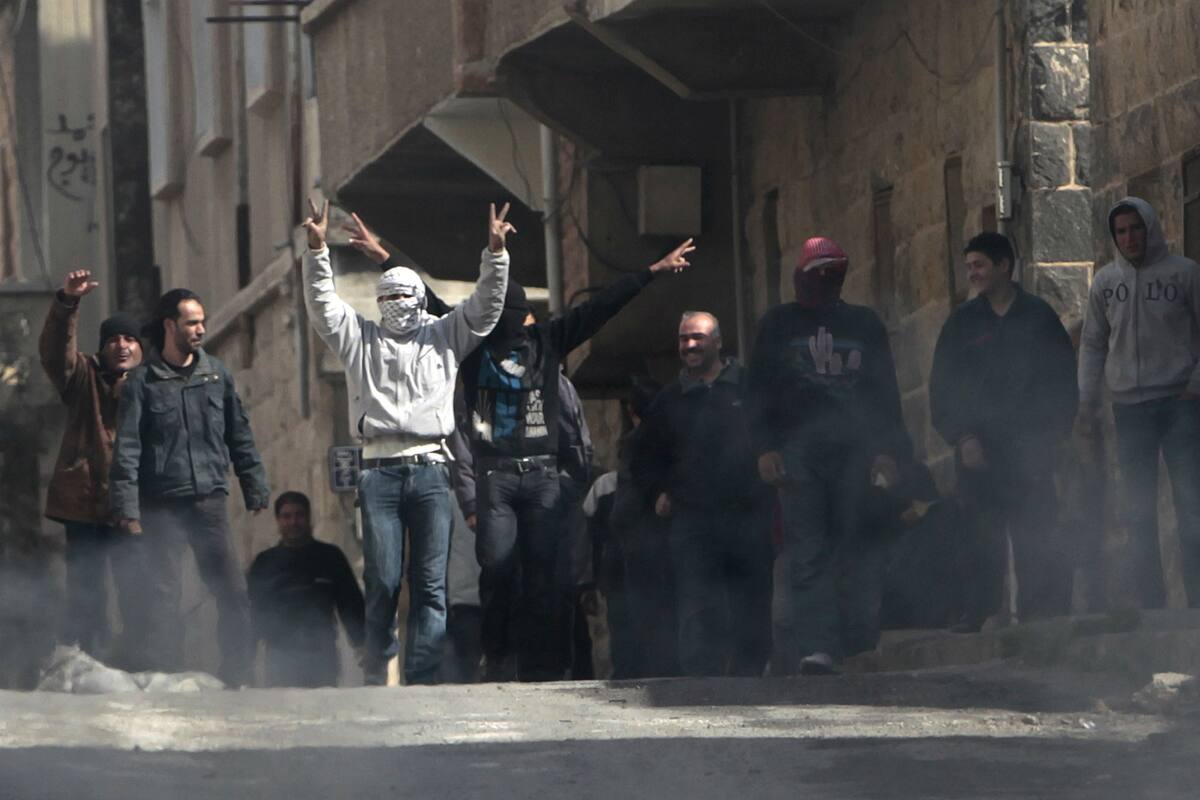 En marzo de 2011, los manifestantes antigubernamentales en Daraa celebran el retroceso de las fuerzas policiales durante el inicio de la revuelta contra Al-Assad