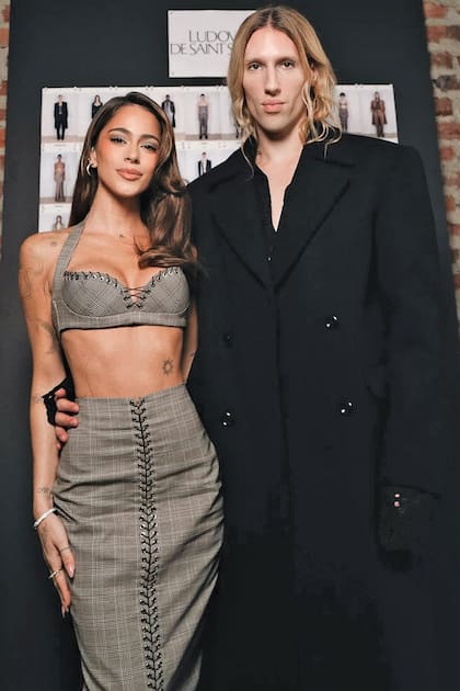En marzo de 2025 comenzó el vínculo de Tini con el diseñador belga. Invitada a su desfile durante la Semana de la Moda de París, la cantante asistió con un exclusivo conjunto de la colección Otoño 2025: un top tipo corset y una falda midi a cuadros grises, ambos intervenidos con los característicos cordones metálicos de la firma