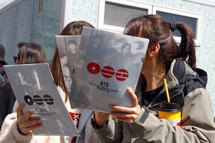 En marzo de 2026, un grupo de fanáticos de BTS en la Plaza Gwanghwamun en Seúl, Corea del Sur, con volantes promocionales para el concierto de regreso de la banda