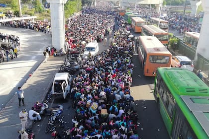 En Nueva Delhi, cientos de miles de personas esperan el transporte público para volver a sus pueblos a cumplir con la cuarentena por el coronavirus