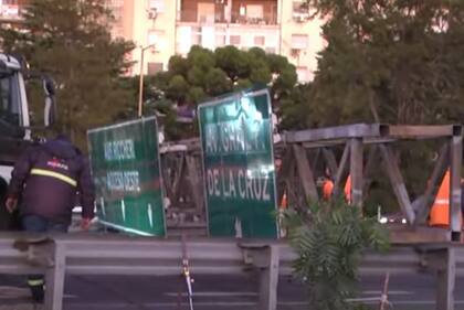 En plena hora pico, técnicos de la concesionaria Ausol trabajaban en el lugar para intentar remover el cartel, ya que uno de sus extremos quedó colgado y corre peligro de derrumbe.