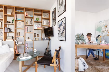Del lado del living, sillón de petiribí con asiento y respaldo de cuero negro con pelo y mesa con tapa de mármol verde (todo de Lacroze Design Studio). Del lado del escritorio, alfombra (Godet House) y cuadro de Alejo Ortiz de Urbina,