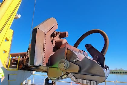 En primer plano, una draga que remueve los sedimentos de los canales de la Hidrovía