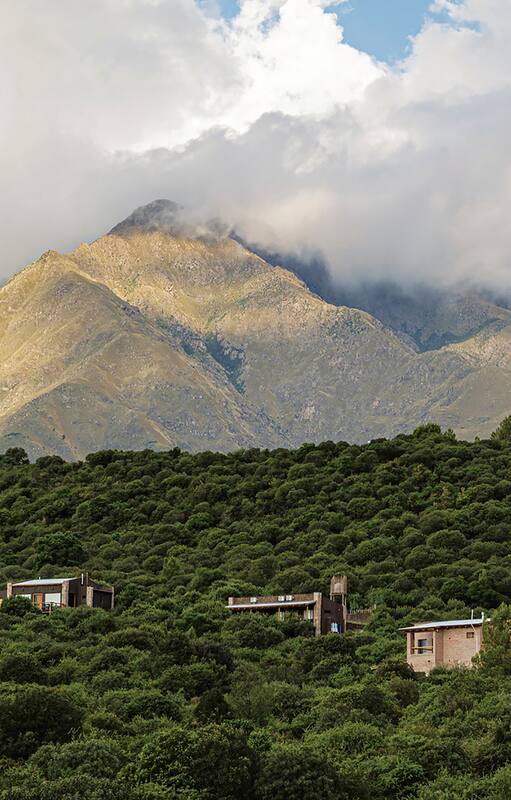 Fresca en verano y cálida en invierno, la casa de adobe y piedra se encuentra parcialmente enterrada (de ahí su mínima transferencia térmica) en el corazón de un inmenso jardín con frutales, aromáticas, huerta y una pileta natural para bañarse entre nenúfares.