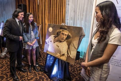 En septiembre de 2015, padre e hija observando una gigantografía de una foto del tenista en acción.