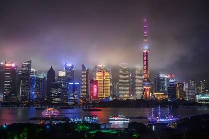 En Shanghai, los barcos viajan por el río Huangpu mientras se ve el horizonte de la ciudad, incluida la Torre de TV Oriental Pearl y la Torre de Shanghai