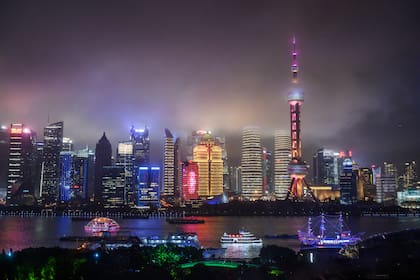 En Shanghai, los barcos viajan por el río Huangpu mientras se ve el horizonte de la ciudad, incluida la Torre de TV Oriental Pearl y la Torre de Shanghai
