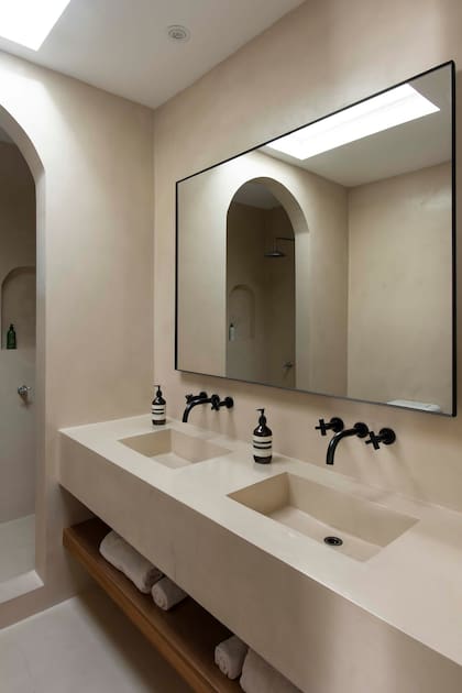 En su baño en suite, Laura Schiebel, creadora de Lau Interiors, revistió las paredes con cemento alisado e hizo la estructura de la pileta en hormigón revestido.