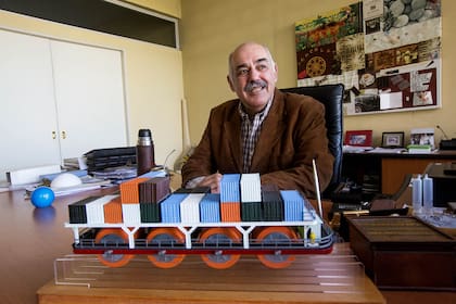 En su escritorio, el inventor argentino Carlos Arcusin muestra una barcaza impulsada por el sistema del principio hidrodinámico que logró confirmar