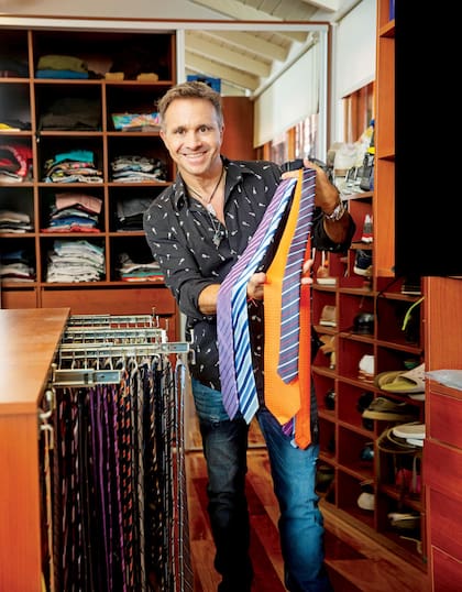 En su guardarropa, con su gran colección de corbatas. La naranja fue un regalo de Daniel Scioli.