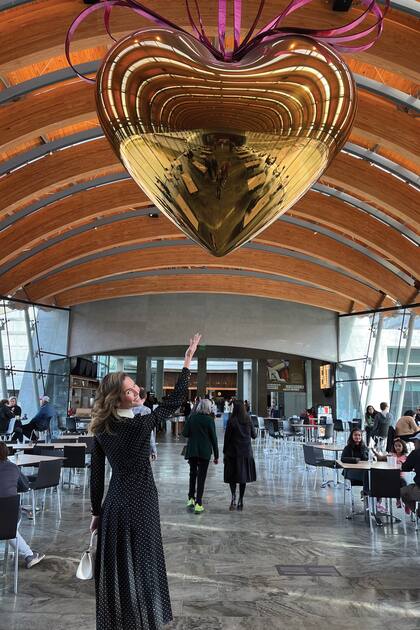 En su paso por el reconocido museo de Arkansas Elina posa mientras señala una obra de Jeff Koons.