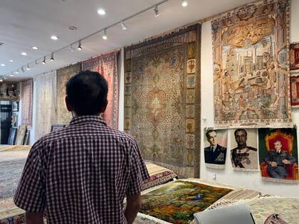 En su tienda de alfombras, Eric Saddith ha colgado en la pared tapices con el retrato del último sha de Irán, Mohamed Reza Pahlavi