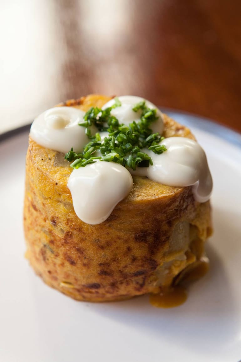 En Toledo la tortilla se hace con papas confitadas, cebollas caramelizadas y sólo yemas pasteurizadas. Sale con mayonesa de limón.