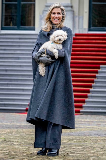 En tono gris azulado, la Reina combinó su abrigo capa con un suéter ajustado de cuello alto y unas botas cortas de taco ancho y suela track de Gianvito Rossi. Este accesorio, el modelo Martis que también tiene en color marrón, lo estrenó el 12 de octubre de 2022.