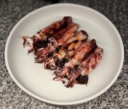 En Ultramarinos, se sirven sobre una intensa base de cebollas, tinta de calamar, pimentón y nduja picante. Luego pasan por las brasas para lograr una cocción precisa que conserve toda su ternura.