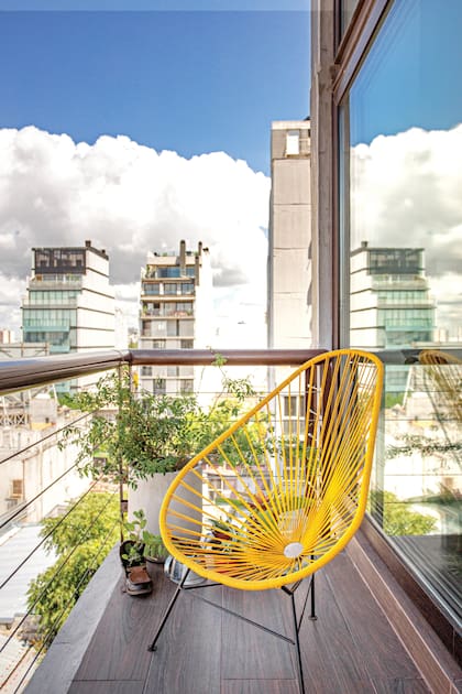 En un balcón angosto, esta silla ‘Acapulco’ en amarillo brillante ofrece comodidad y un acento de diseño que enriquece el interior.