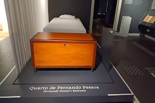 Una pequeña cama, la máquina de escribir negra y cientos de libros que parecen volar