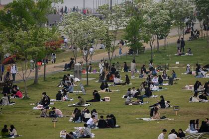 En una foto tomada el 10 de mayo, las personas se sientan en un parque en Seúl. Corea del Sur anunció su mayor número de casos nuevos de coronavirus en más de un mes el 11 de mayo, impulsado por un foco en un distrito de vida nocturna de la capital justo cuando el país afloja las restricciones