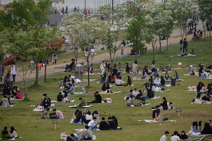 En una foto tomada el 10 de mayo, las personas se sientan en un parque en Seúl. Corea del Sur anunció su mayor número de casos nuevos de coronavirus en más de un mes el 11 de mayo, impulsado por un foco en un distrito de vida nocturna de la capital justo cuando el país afloja las restricciones