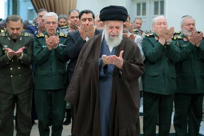 En una fotografía difundida por el sitio oficial de la oficina del máximo líder religioso de Irán, el ayatolá Alí Ali Khamenei, centro, ofrece una oración durante una reunión con jefes militares en Teherán, Irán, el domingo 21 de abril de 2024.