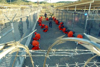 En una imagen publicada por el Departamento de Defensa, los primeros 20 detenidos llevados a la Base Naval de Guantánamo, son mantenidos en un recinto de alambre de púas poco después de su llegada el 11 de enero de 2002.