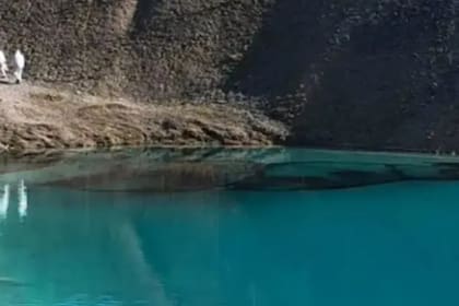 En una publicación de Facebook, la policía mostró las imágenes de dos agentes con máscaras y trajes de protección, que realizaron el teñido del agua de la cantera