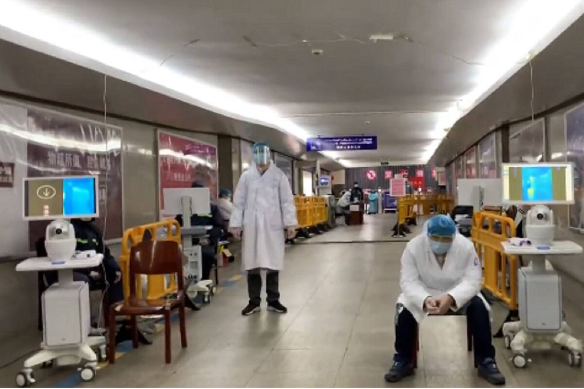 En Yiwu, autoridades locales y voluntarios en trajes protectores improvisados revisan los celulares de los que ingresan en una estación de trenes