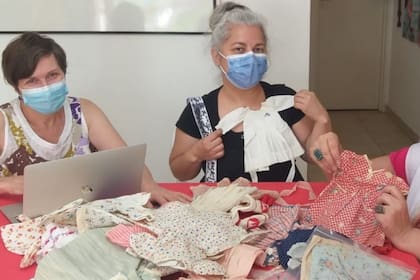 En2021, todavía con barbijos, Daniela junto con Cristina Quiroga Pellet, experta en conservación y restauración de textiles, y Elsa Keller, modista de muñecas, restauradora y coleccionista, analizan el guardarropas de Marilú.