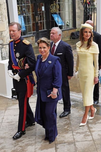 Encabezando la entrada a la abadía, los Grandes Duques de Luxemburgo Enrique y María Teresa, con un Alexander McQueen; detrás, los reyes de Jordania Abdullah II y Rania, con un diseño de Tamara Ralph y clutch de Bottega Veneta.