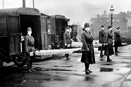Enfermeras junto a ambulancias en 1918, durante la pandemia de gripe española