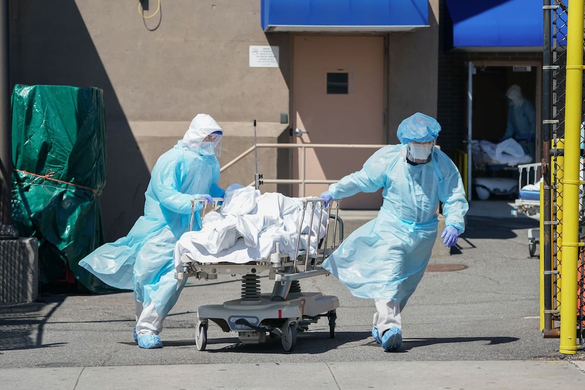 Enfermeros trasladan un cuerpo a un camión refrigerador utilizado como morgue temporaria en el Hospital Wyckoff, en Nueva York