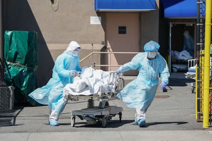 Enfermeros trasladan un cuerpo a un camión refrigerador utilizado como morgue temporaria en el Hospital Wyckoff, en Nueva York; Estados Unidos, el país con más contagios del mundo